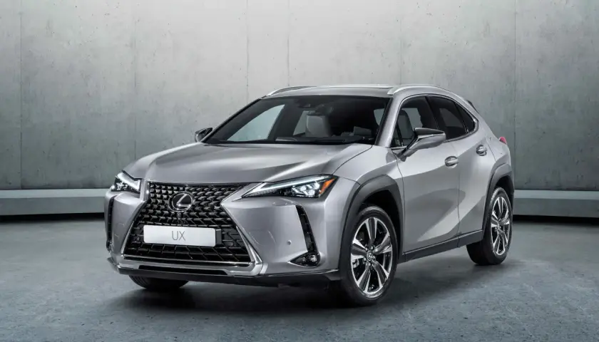 Srebrny Lexus UX 250h stoi na tle betonowej ściany. Elegancki crossover miejski gotowy na przygodę.