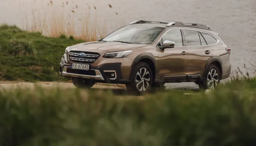 Brązowy Subaru Outback 2025 zaparkowany nad jeziorem, gotowy na przygodę.