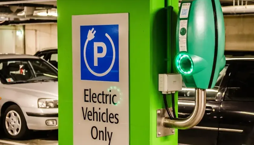 Zielona ładowarka EVbox i znak "Electric Vehicles Only" w garażu podziemnym. Zastanawiasz się, ile kosztuje ładowanie samochodu elektrycznego?