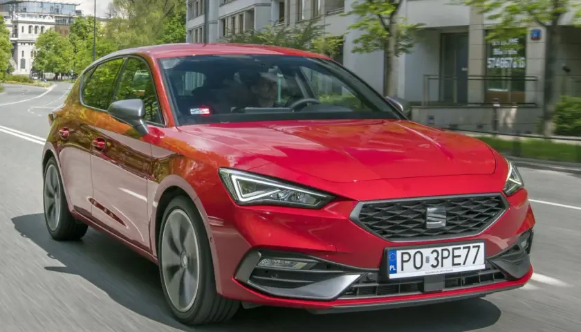 Czerwony SEAT Leon 4 w ruchu miejskim.