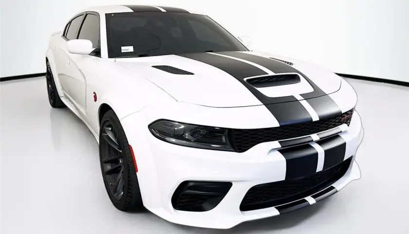 Biały Dodge Charger SRT z czarnymi pasami na masce i dachu, gotowy do jazdy.