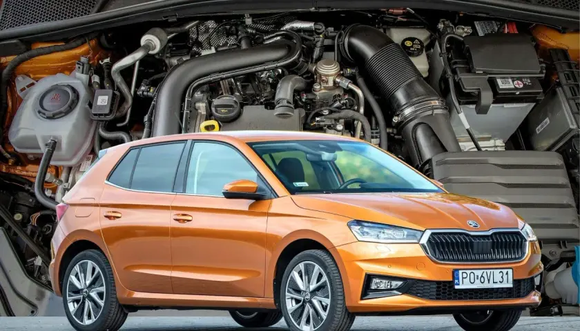 Pomarańczowa Skoda Fabia IV z widocznym silnikiem w tle.