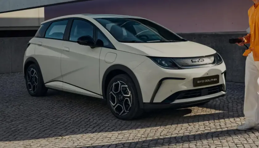 Biały BYD Dolphin, jeden z chińskich samochodów elektrycznych, gotowy do ładowania.