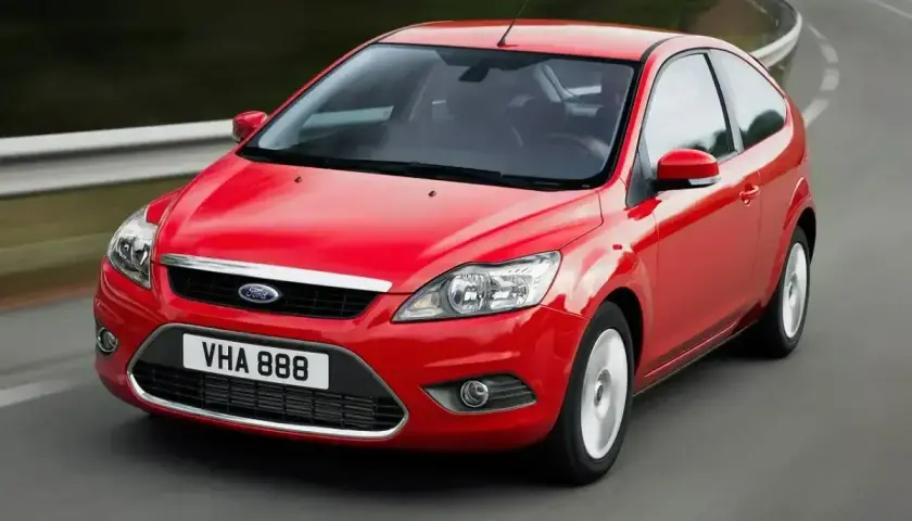 Czerwony Ford Focus MK2 1.6 benzyna w ruchu na zakręcie drogi.