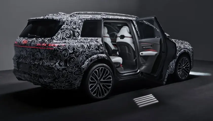 Nowy Audi Q9 w kamuflażu, z otwartymi drzwiami, prezentuje luksusowe wnętrze. Czekamy na jego cenę i premierę!