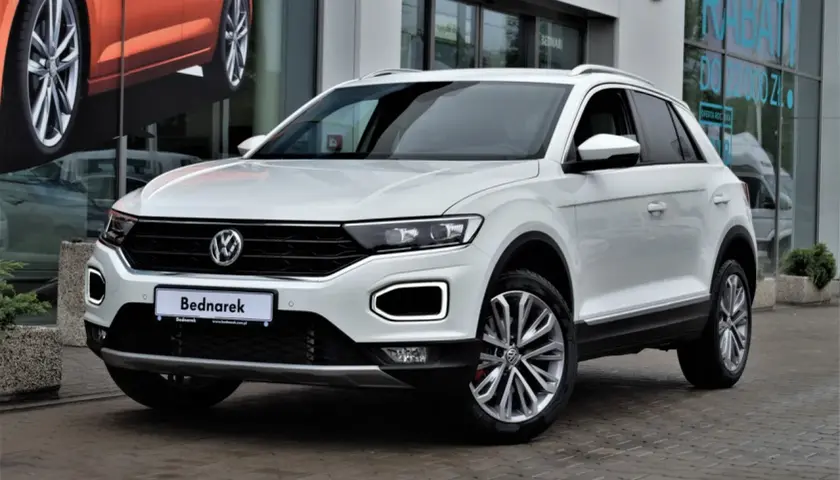 Biały Volkswagen T-Roc, jeden z popularnych volkswagen suv modele, zaparkowany przed salonem.