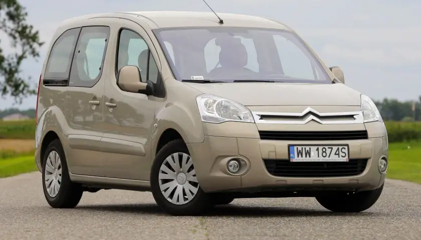 Beżowy Citroen Berlingo 2 na drodze, z widocznym kierowcą za kierownicą.