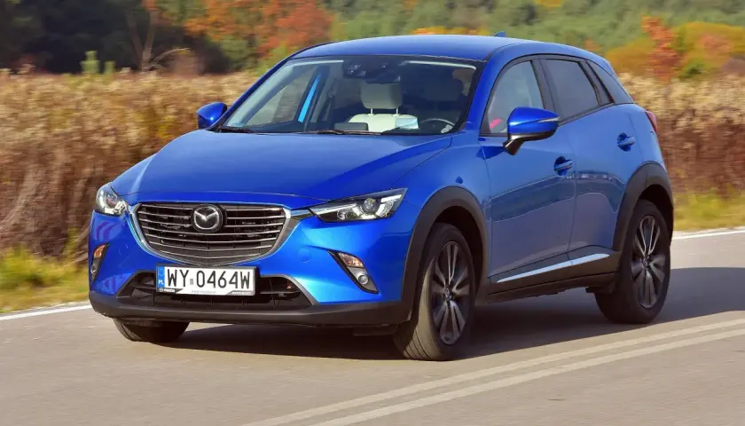 Niebieska Mazda CX-3 na drodze. Wiele pozytywnych mazda cx-3 opinie potwierdza jej stylowy wygląd i dynamikę jazdy.