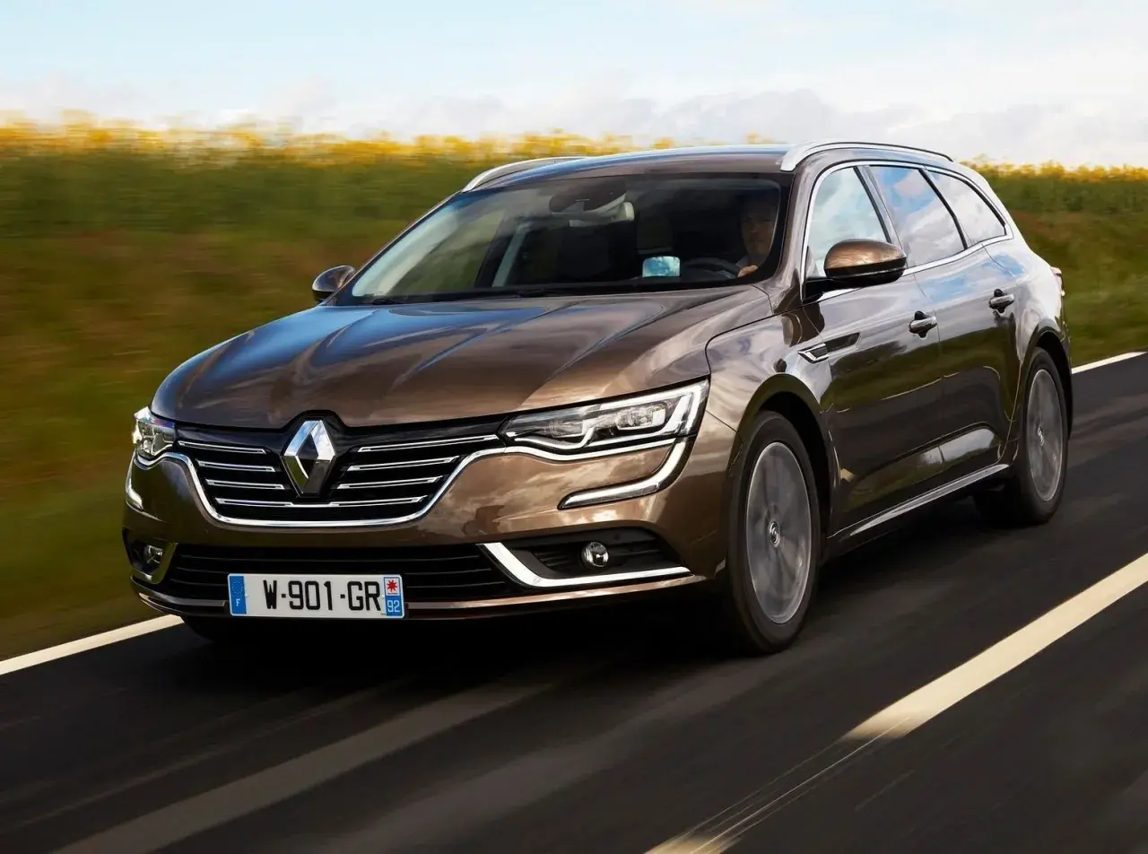 Brązowe kombi Renault Talisman na drodze. Wiele osób szuka renault talisman opinie przed zakupem.