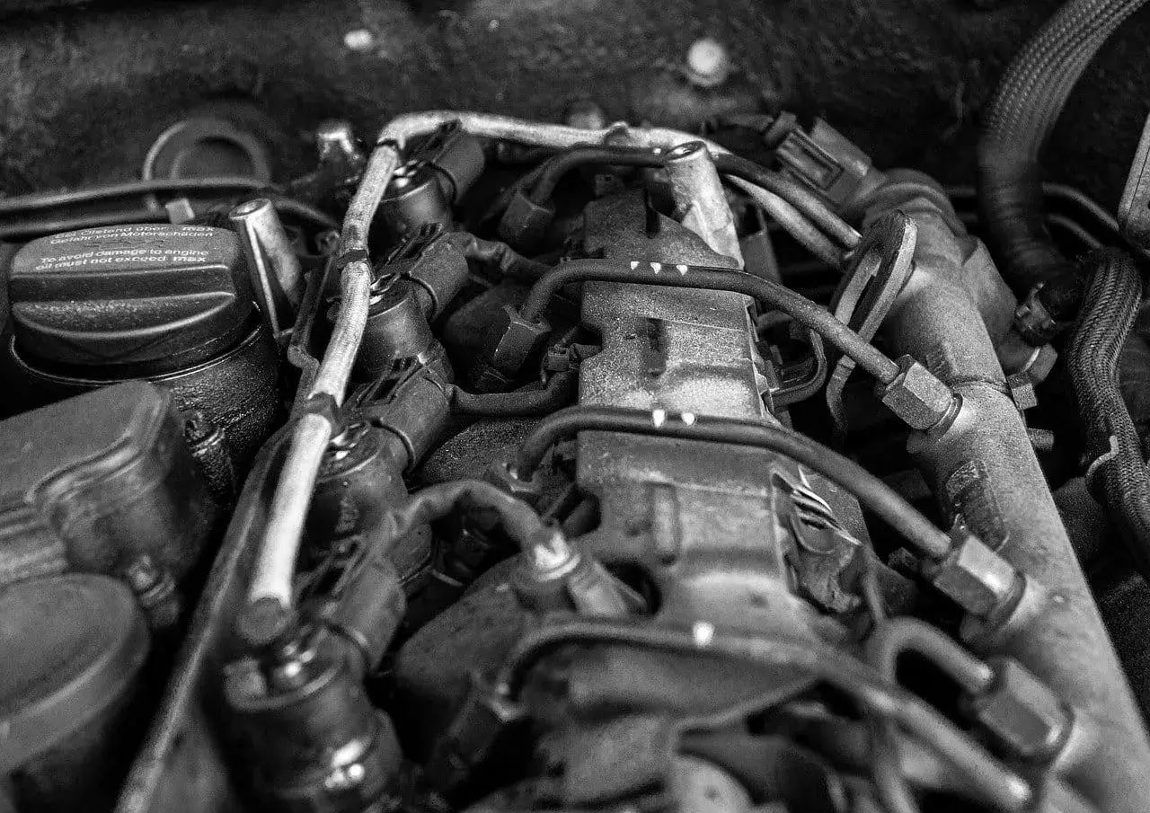 Widok silnika samochodowego, z widocznym korkiem wlewu oleju z napisem "To avoid damage to engine oil must not exceed max". Może to sugerować, że jest za dużo oleju w silniku.