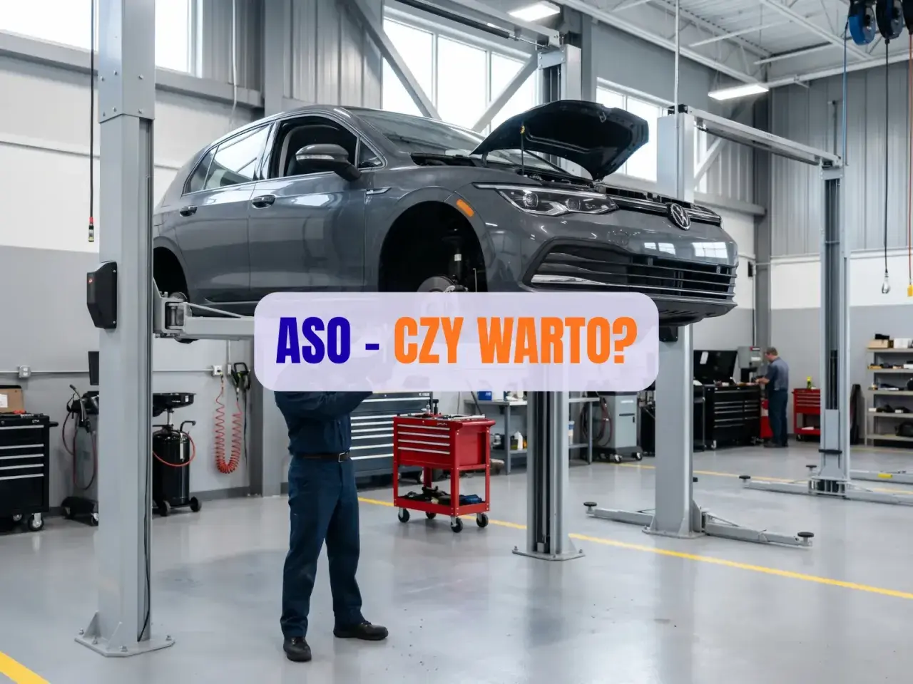 Mechanik pracuje pod samochodem na podnośniku w ASO. Czy warto?