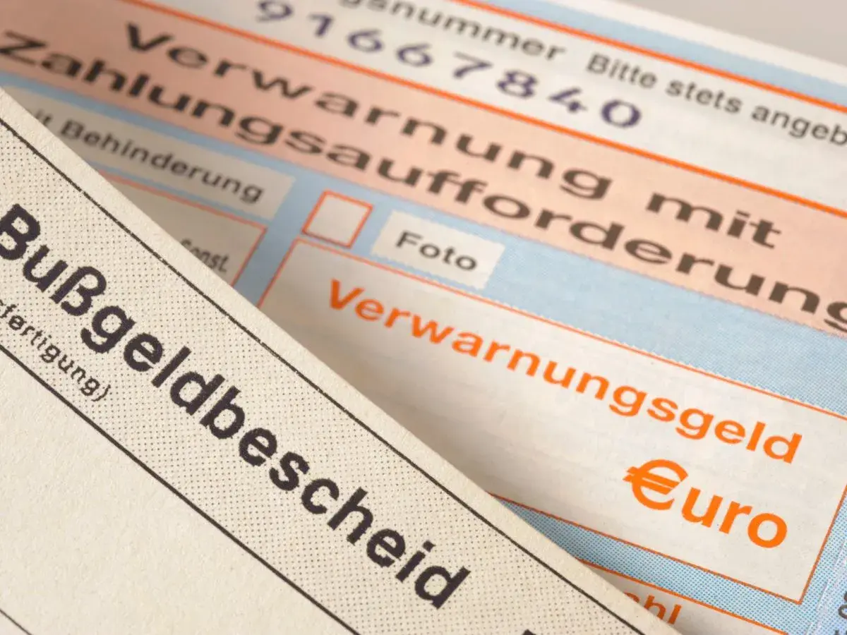 Zbliżenie na niemieckie mandaty, w tym "Bußgeldbescheid" i "Verwarnungsgeld" z symbolem euro.