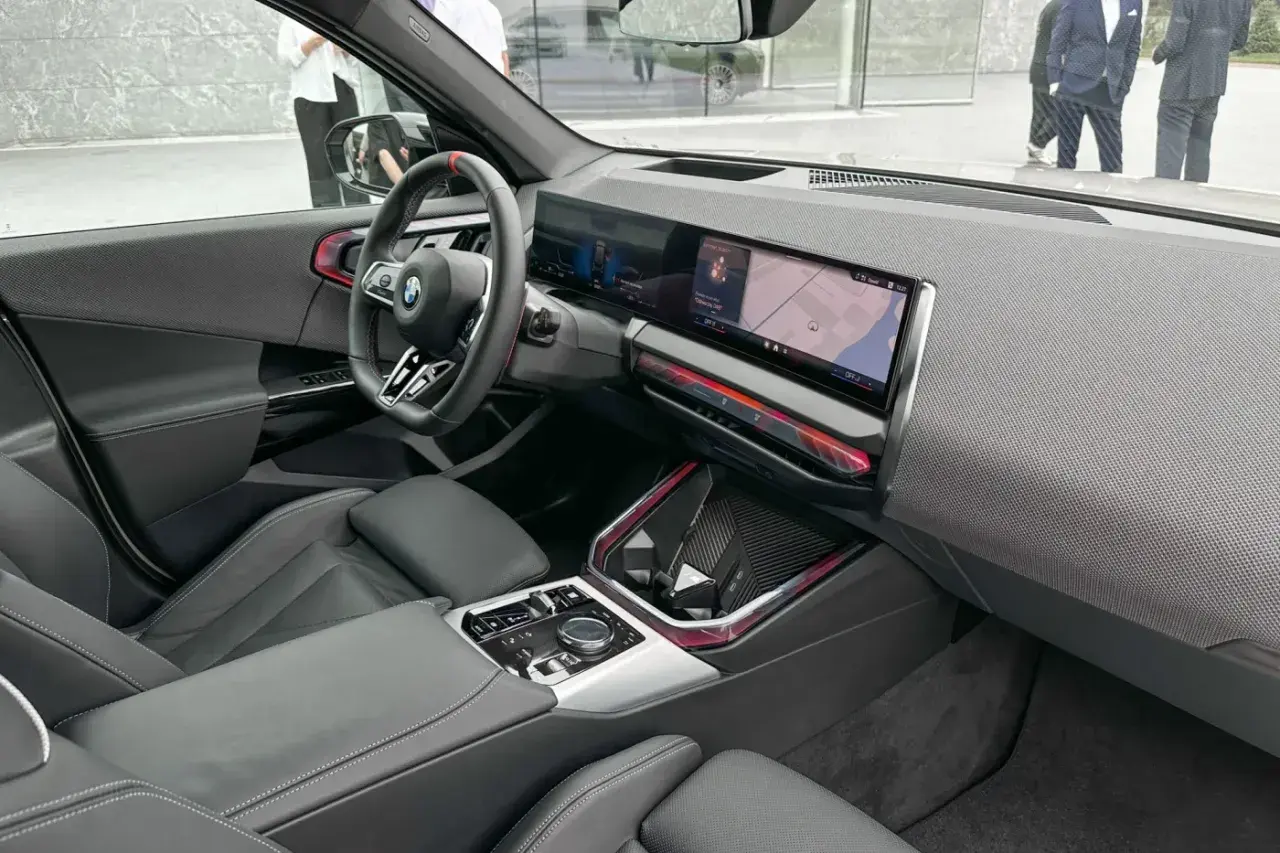 Wnętrze BMW X3 2025 z nowoczesnym ekranem multimedialnym i sportową kierownicą.