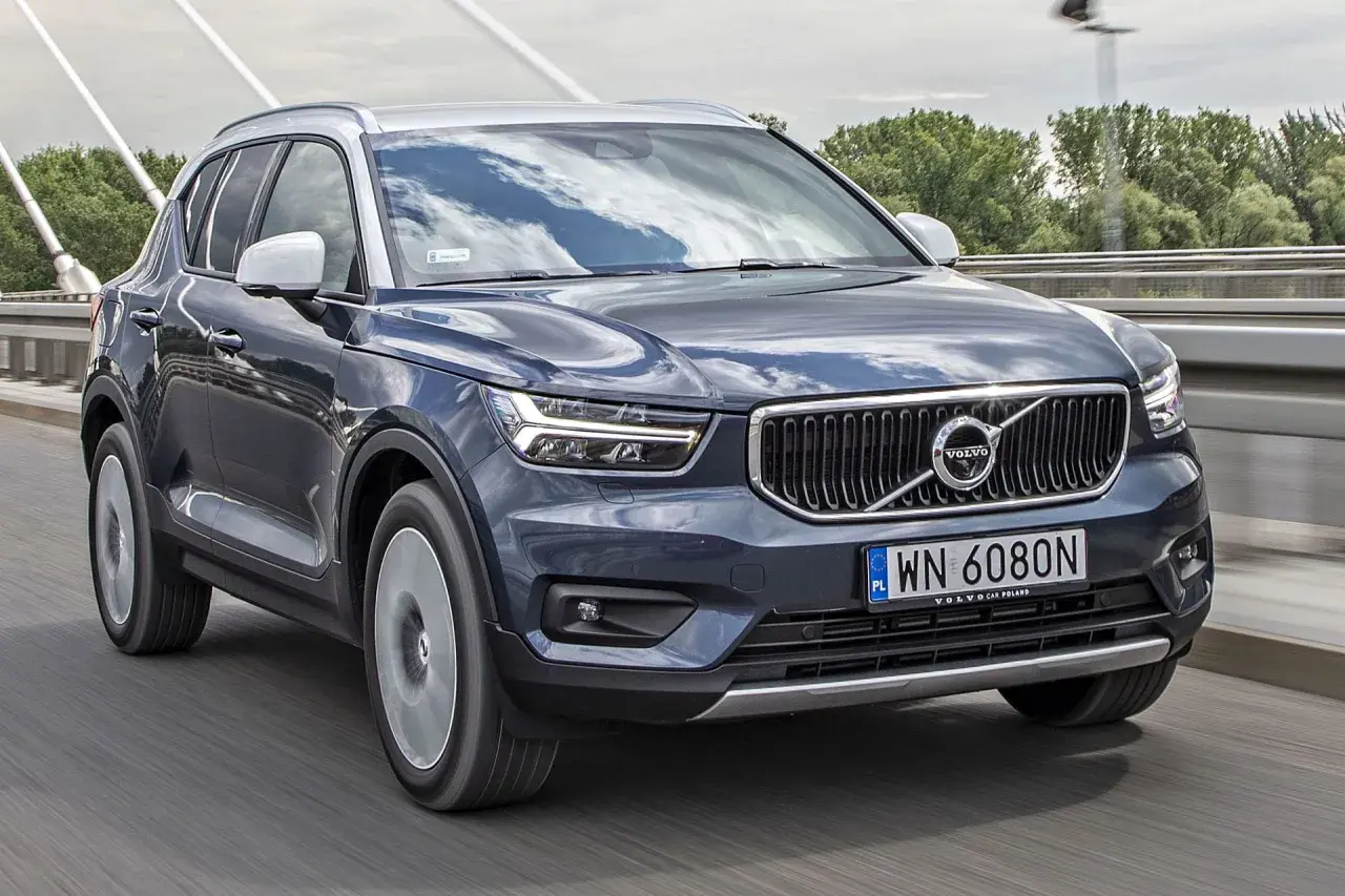 Ciemnoszary Volvo XC40 jedzie po moście. Sprawdź aktualną volvo xc40 cena i dostępne wersje.