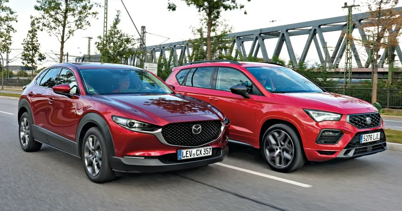 Dwa czerwone SUV-y jadące obok siebie. Po lewej Mazda CX-30, po prawej Seat Ateca. Porównanie mazda cx 30 wymiary.