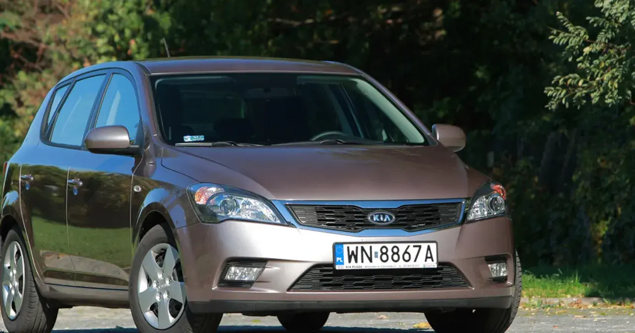 Brązowe Kia Ceed z przodu, na tle zieleni.