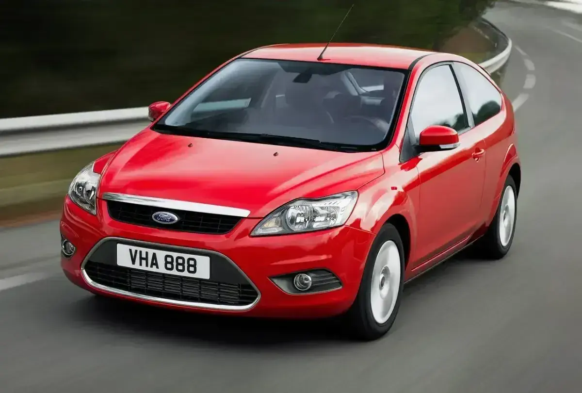 Czerwony Ford Focus MK2 1.6 benzyna w ruchu na zakręcie drogi.