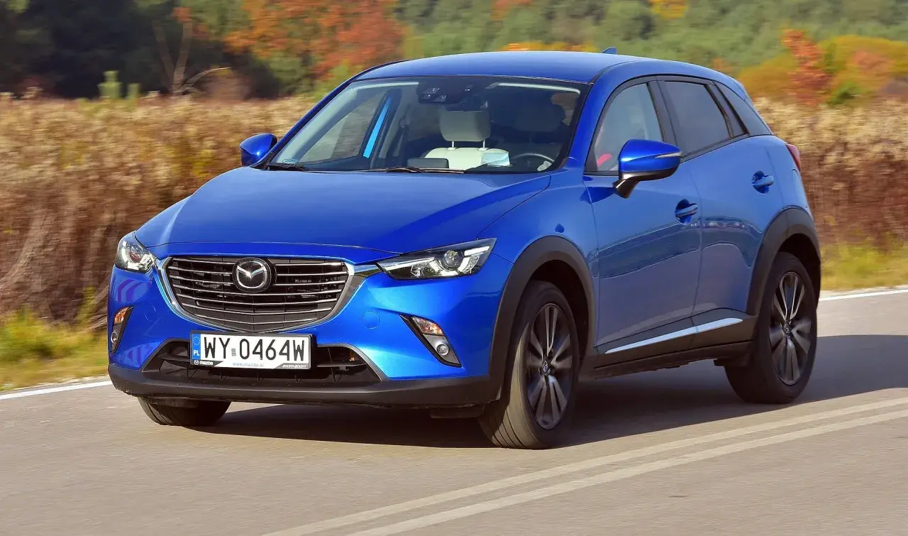 Niebieska Mazda CX-3 na drodze. Wiele pozytywnych mazda cx-3 opinie potwierdza jej stylowy wygląd i dynamikę jazdy.