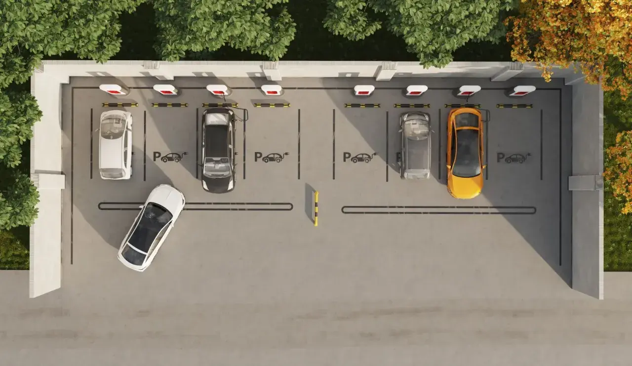 Widok z góry na parking z kilkoma samochodami, w tym żółtym i białym. Widać ładowarki do samochodów elektrycznych, sugerujące funkcję asystenta parkowania.