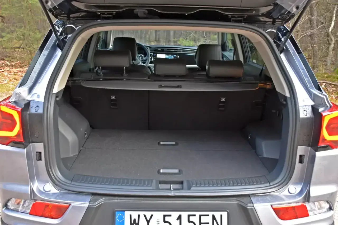 Otwarty bagażnik Ssangyong Korando, przestronny i gotowy na podróż. Użytkownicy chwalą jego pojemność w swoich opiniach.