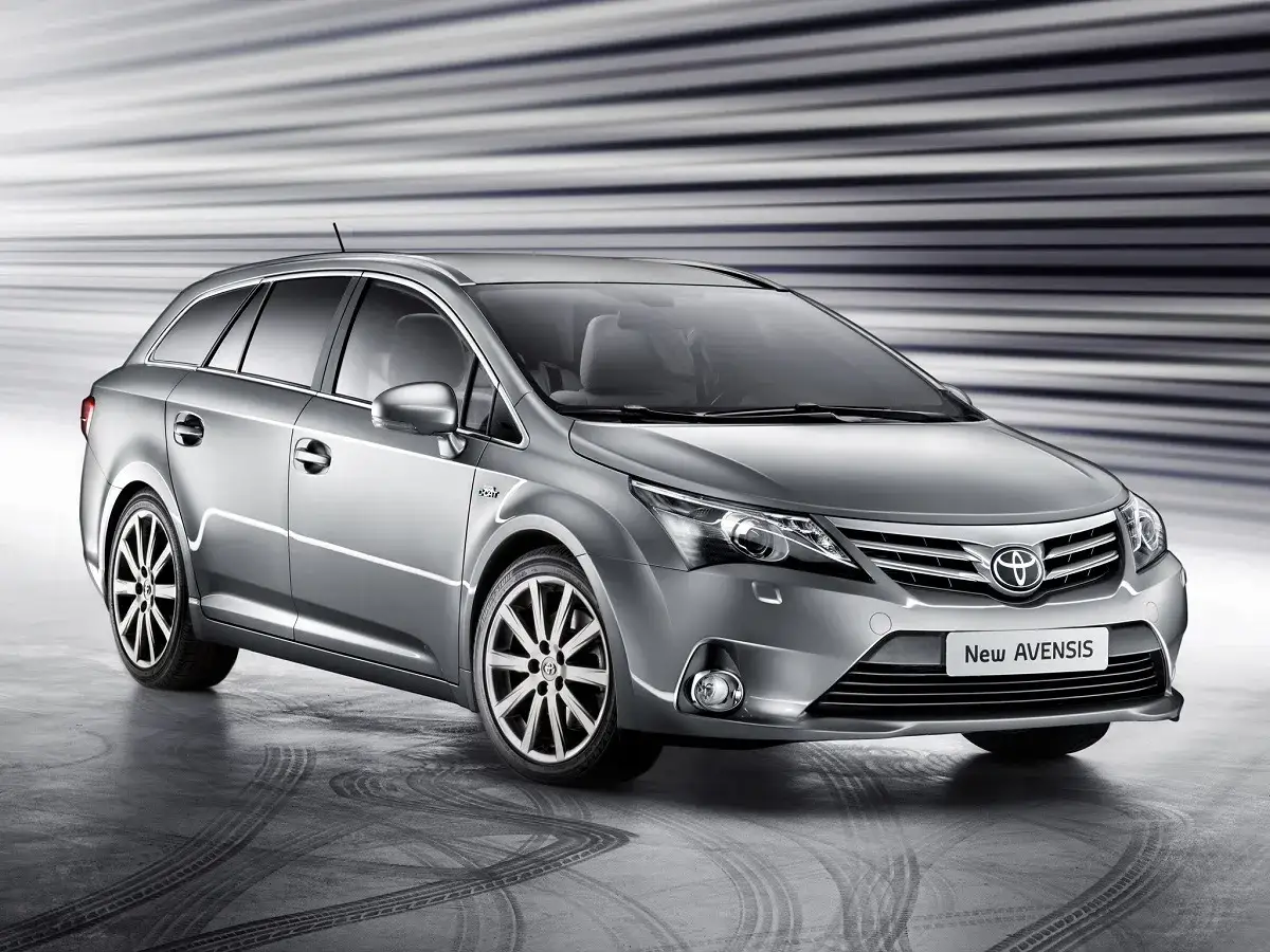 Srebrny kombi Toyota Avensis T27 z felgami i dynamicznym tłem.