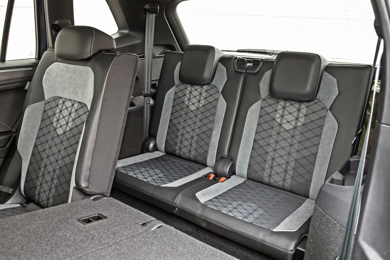 Wnętrze Tiguan Allspace z wygodnymi, tapicerowanymi siedzeniami i pasami bezpieczeństwa.