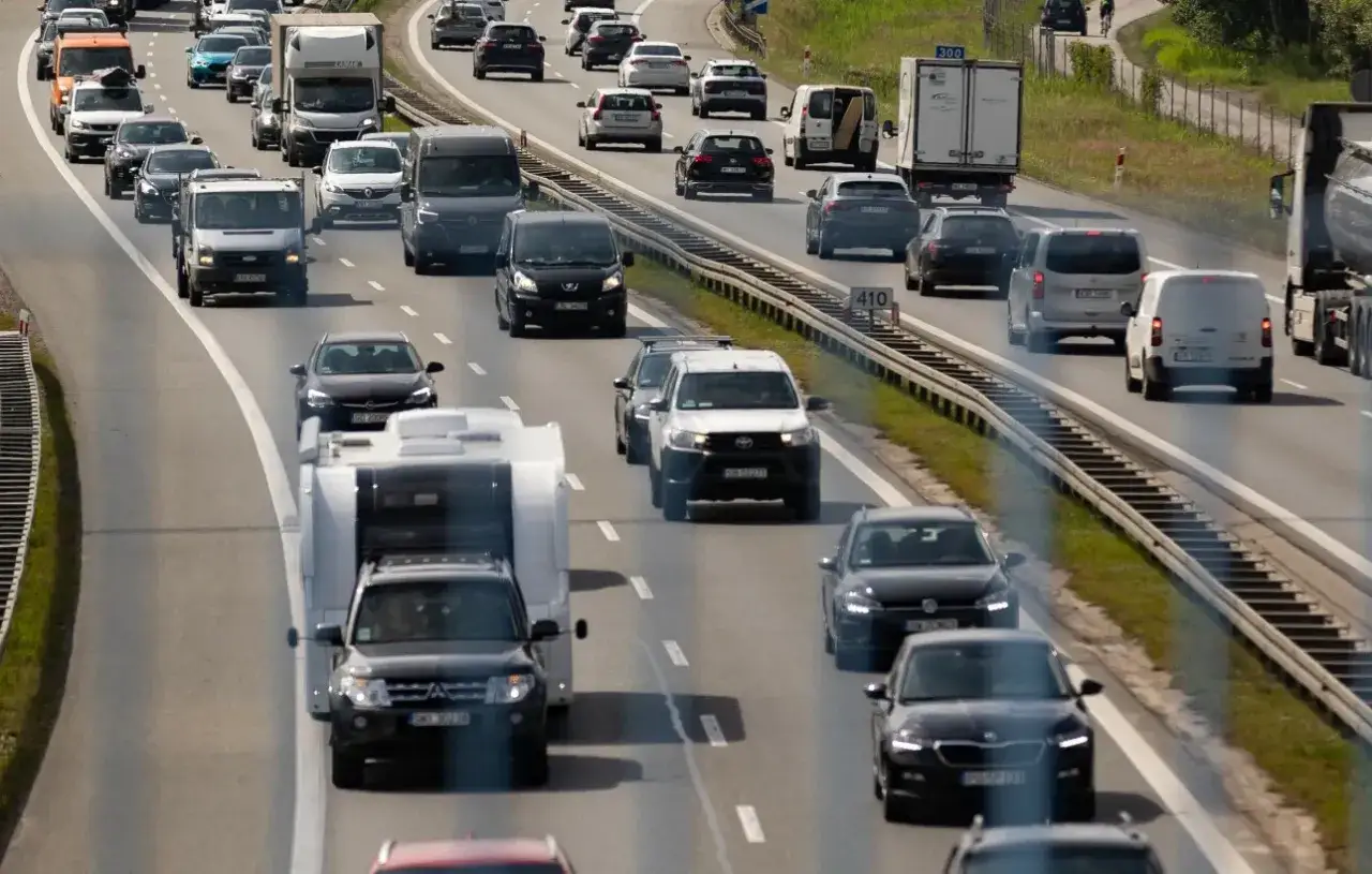 Korki na autostradzie, gdzie wiele samochodów z przyczepkami zastanawia się, ile można jechać.