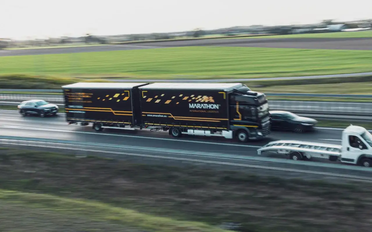Ciężarówka Marathon na autostradzie, przewożąca ładunek. To przykład transportu, który może być związany z kabotażem, czyli przewozem towarów wewnątrz kraju przez zagranicznego przewoźnika.