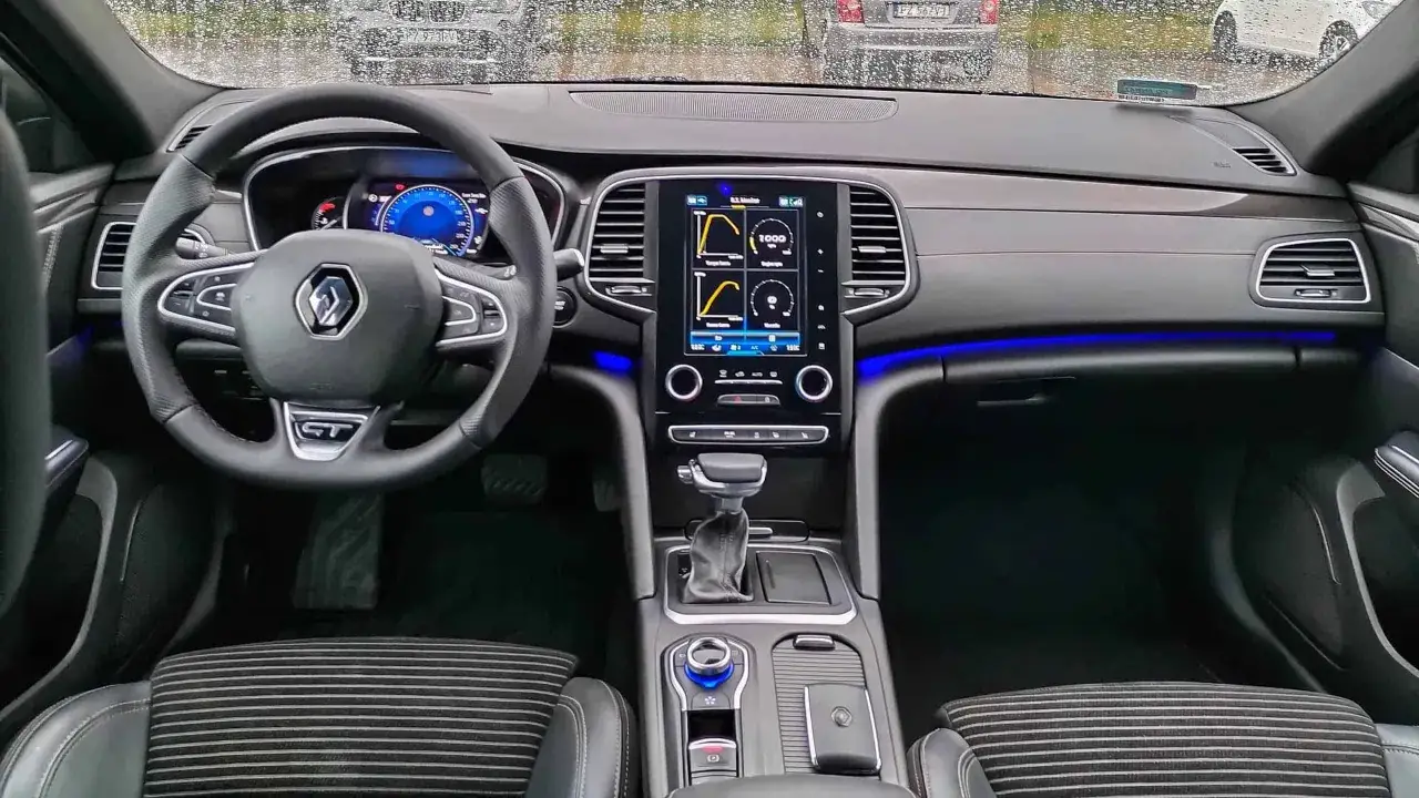 Wnętrze Renault Talisman: kierownica, ekran multimediów z wykresami, deska rozdzielcza. Wiele osób szuka renault talisman opinie przed zakupem.