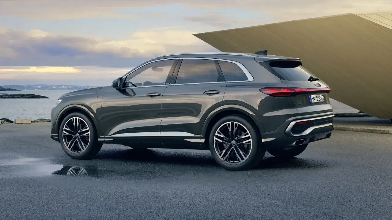 Elegancki Audi Q5 w ciemnoszarym kolorze, zaparkowany nad wodą. Poznaj jego imponujące audi q5 wymiary i ciesz się podróżą.