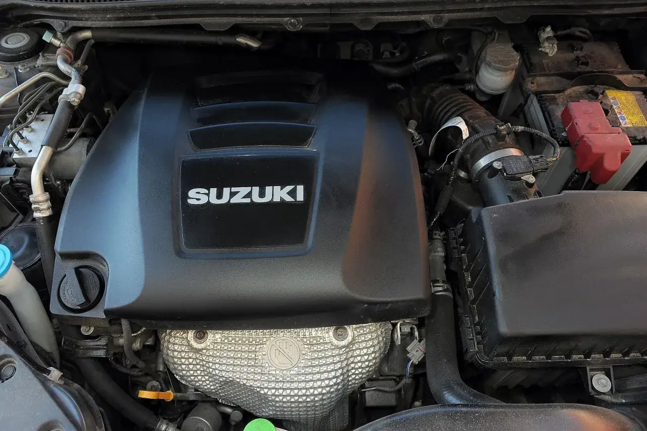 Silnik Suzuki Kizashi z widocznym logo producenta na czarnej osłonie.