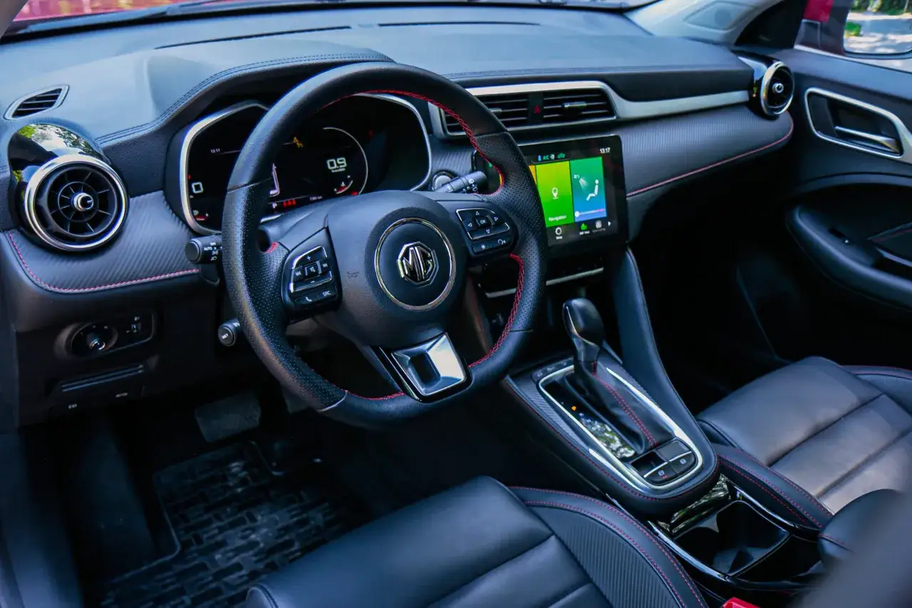 Wnętrze MG ZS. Kierownica, ekran multimediów i fotel kierowcy. Wiele osób szuka mg zs opinie przed zakupem.