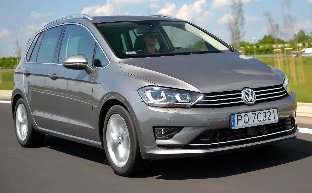 Szary Volkswagen Golf Sportsvan w ruchu drogowym. Wady tego modelu mogą obejmować ograniczoną przestrzeń bagażową w porównaniu do innych kombi.
