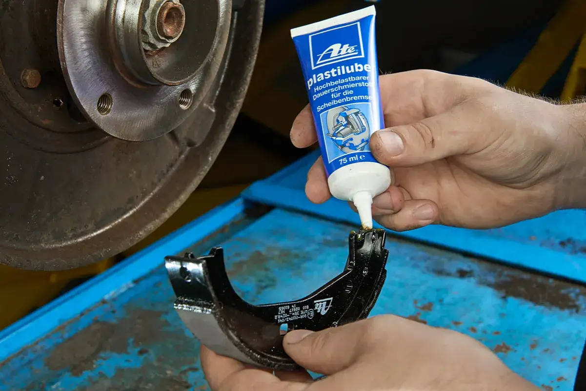 Mechanik aplikuje smar ATE Plastilube na prowadnice hamulcowe, by zapewnić ich płynne działanie.
